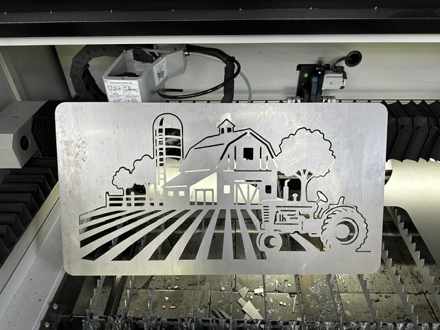 Detailed laser-cut metal farm scene with barn, tractor and fields
